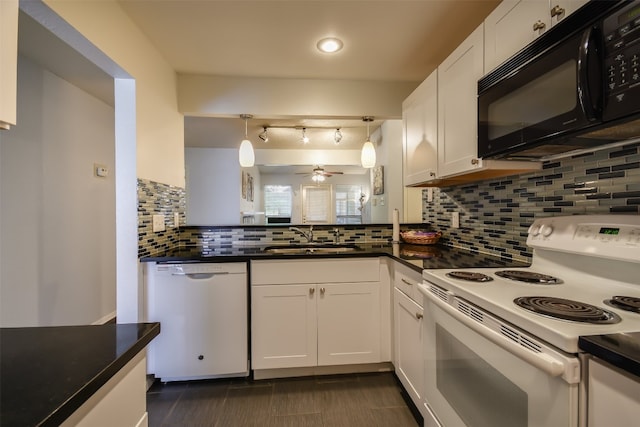 kitchen featuring white appliances, dark countertops, ceiling fan, and a sink