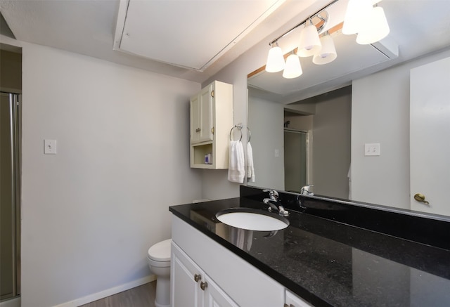 bathroom with vanity, toilet, baseboards, wood finished floors, and an enclosed shower