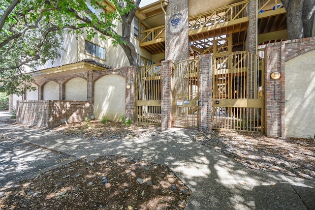 exterior space featuring a gate and brick siding