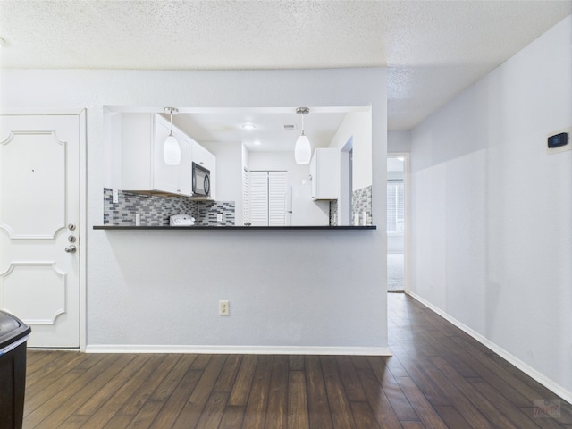 806 W 24th St Unit 312, Austin, TX 78705 - kitchen with dark countertops, black microwave, baseboards, and backsplash