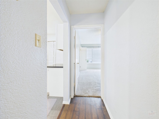 806 W 24th St Unit 312, Austin, TX 78705 - hallway featuring a textured wall, dark wood-type flooring, and baseboards