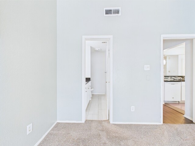 806 W 24th St Unit 312, Austin, TX 78705 - unfurnished bedroom with light colored carpet, baseboards, and ensuite bathroom