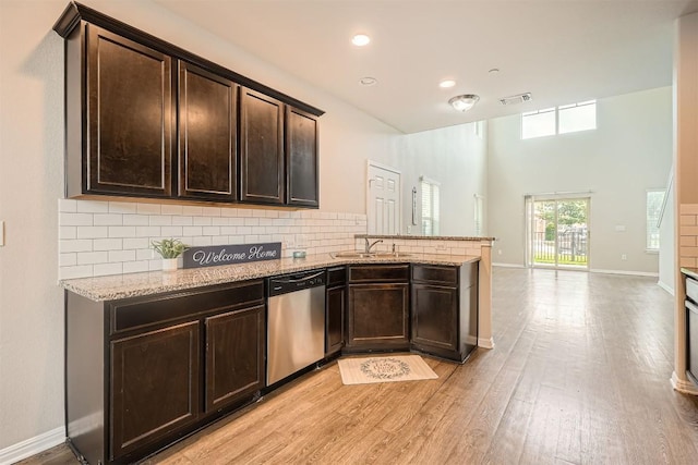516 E Slaughter Ln Unit 1101, Austin, TX 78744 - kitchen featuring stainless steel dishwasher, a peninsula, dark brown cabinetry, a sink, and backsplash