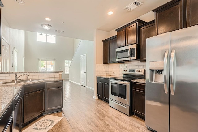 516 E Slaughter Ln Unit 1101, Austin, TX 78744 - kitchen with backsplash, stainless steel appliances, visible vents, and a sink