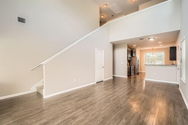 516 E Slaughter Ln Unit 1101, Austin, TX 78744 - unfurnished living room with stairway, baseboards, dark wood-style flooring, and visible vents