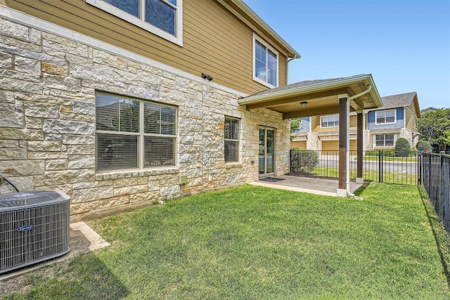 516 E Slaughter Ln Unit 1101, Austin, TX 78744 - rear view of house with fence, stone siding, cooling unit, a patio, and a yard
