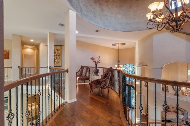 12804 Arbor Lake Cv, Austin, TX 78732 - hallway with wood-type flooring, an inviting chandelier, visible vents, and an upstairs landing