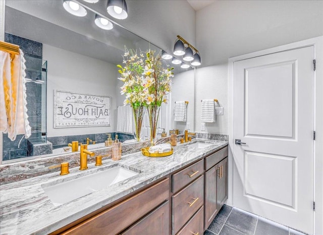 bathroom with a sink, tile patterned flooring, a tile shower, and double vanity
