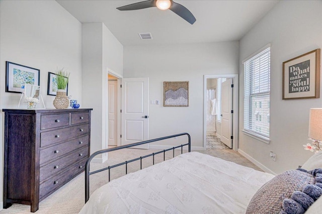 bedroom featuring ceiling fan, visible vents, carpet floors, baseboards, and ensuite bath