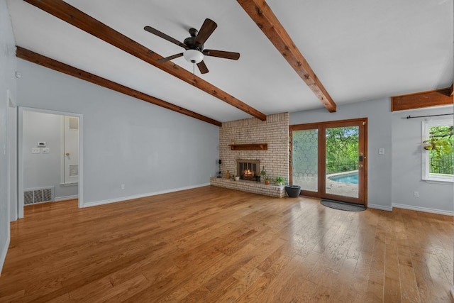 unfurnished living room with lofted ceiling with beams, a ceiling fan, wood finished floors, and visible vents