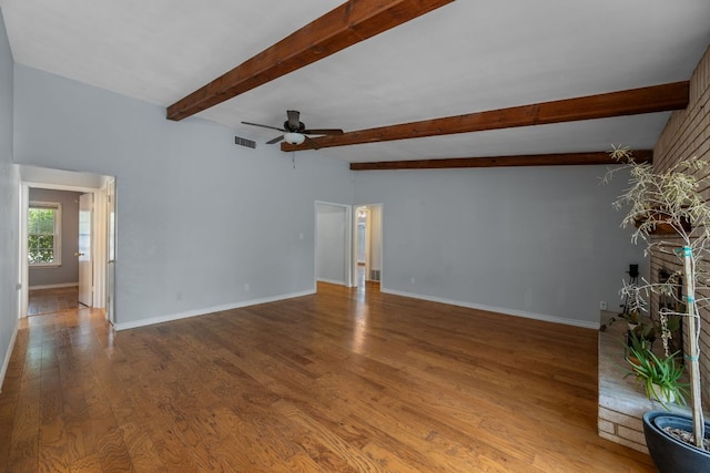 empty room with visible vents, wood finished floors, beam ceiling, baseboards, and ceiling fan