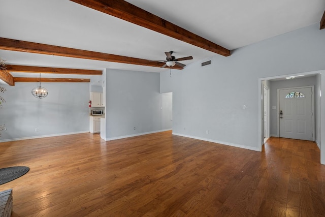 unfurnished living room with baseboards, beam ceiling, ceiling fan with notable chandelier, and wood finished floors