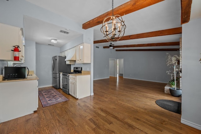 kitchen featuring appliances with stainless steel finishes, wood finished floors, light countertops, beamed ceiling, and white cabinetry