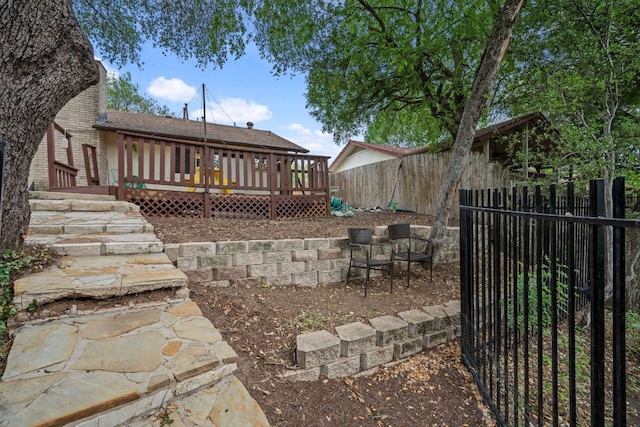 back of property featuring a wooden deck, a fenced backyard, and roof with shingles