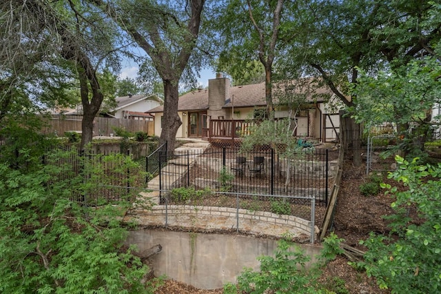 view of front of home with fence private yard, stucco siding, and a chimney