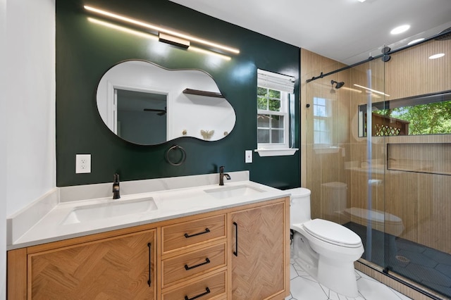 full bathroom featuring double vanity, toilet, a sink, and a stall shower