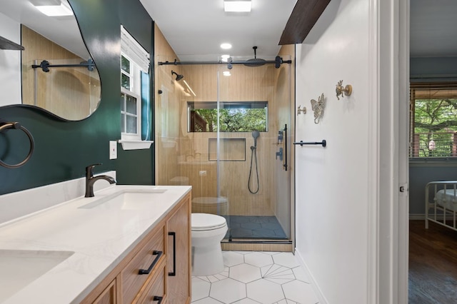 bathroom with toilet, vanity, tile patterned floors, a shower stall, and baseboards
