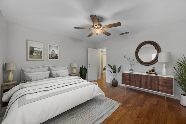 bedroom with baseboards, a ceiling fan, dark wood-style floors, and visible vents