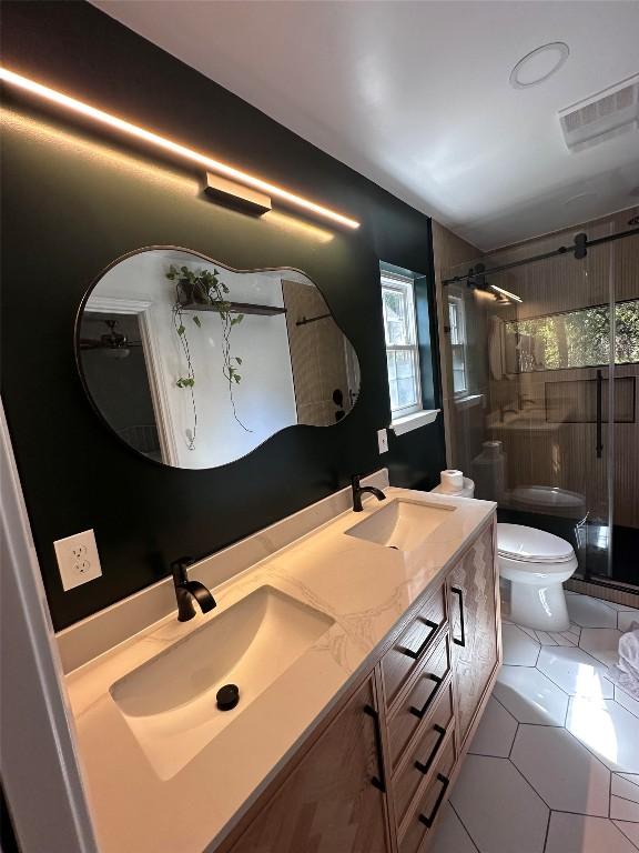 bathroom featuring visible vents, a sink, a stall shower, and toilet