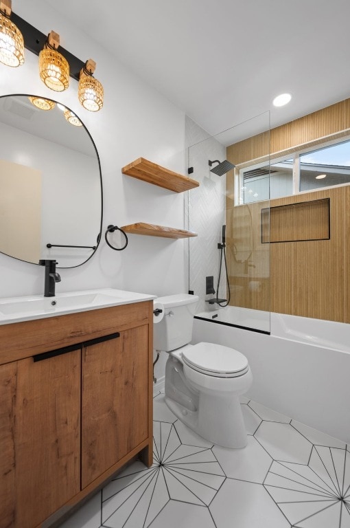 bathroom featuring toilet, vanity, and shower / washtub combination