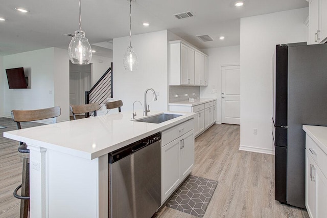 kitchen with visible vents, a sink, a kitchen breakfast bar, and stainless steel appliances