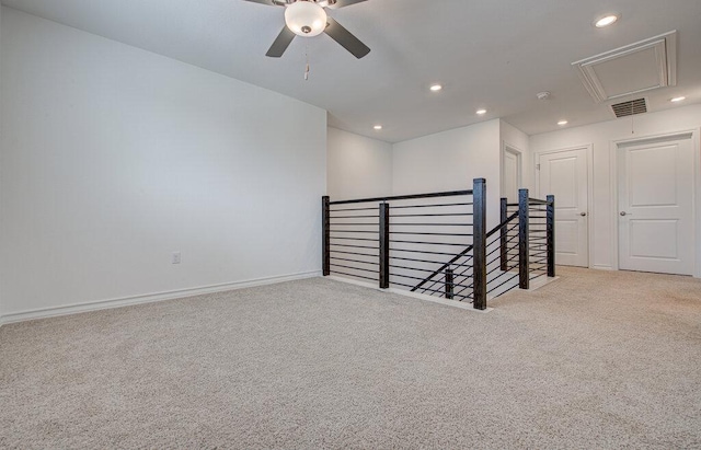 empty room with recessed lighting, attic access, a ceiling fan, and carpet flooring