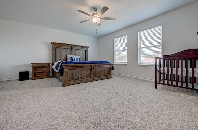 carpeted bedroom featuring baseboards and ceiling fan