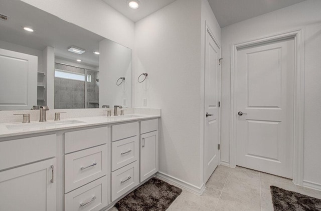 bathroom with double vanity, tile patterned floors, a sink, and a stall shower
