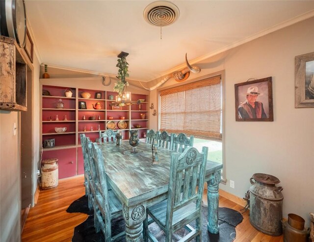 1207 Flag St, Llano, TX 78643 - dining space with an inviting chandelier, ornamental molding, wood finished floors, and visible vents