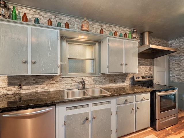 1207 Flag St, Llano, TX 78643 - kitchen with stainless steel appliances, a sink, wall chimney exhaust hood, and tasteful backsplash