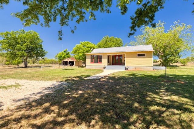 view of front of house with french doors, fence, metal roof, and a front lawn