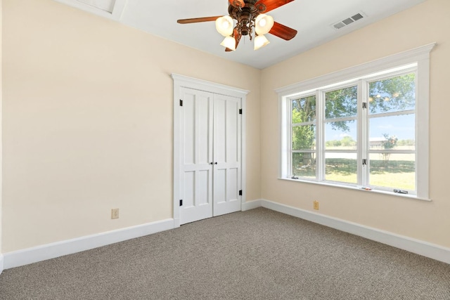 unfurnished bedroom featuring ceiling fan, carpet, baseboards, visible vents, and a closet