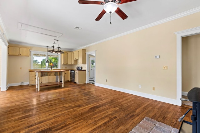 unfurnished living room with ceiling fan, attic access, dark wood-style flooring, baseboards, and ornamental molding