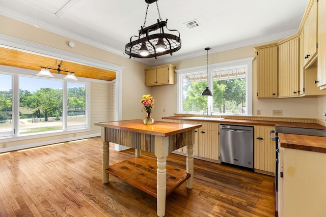kitchen featuring cream cabinetry, stainless steel dishwasher, wooden counters, and visible vents
