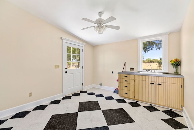interior space with a sink, baseboards, and a ceiling fan