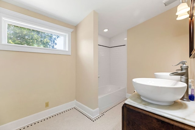 bathroom with baseboards, bathtub / shower combination, and vanity