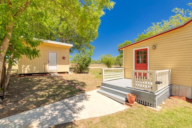view of yard featuring a shed, an outbuilding, and a deck