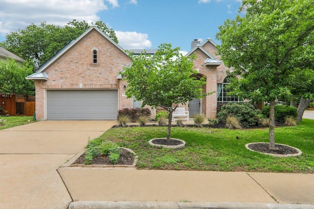view of front facade with fence, a front yard, driveway, and brick siding