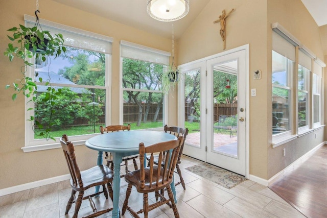 sunroom with baseboards, french doors, and lofted ceiling