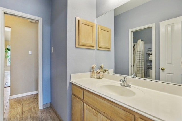 full bath featuring baseboards, curtained shower, and vanity