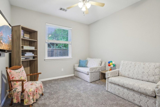 living area featuring carpet floors, ceiling fan, visible vents, and baseboards