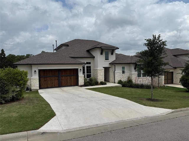 view of front facade featuring a front yard, stone siding, stucco siding, an attached garage, and driveway