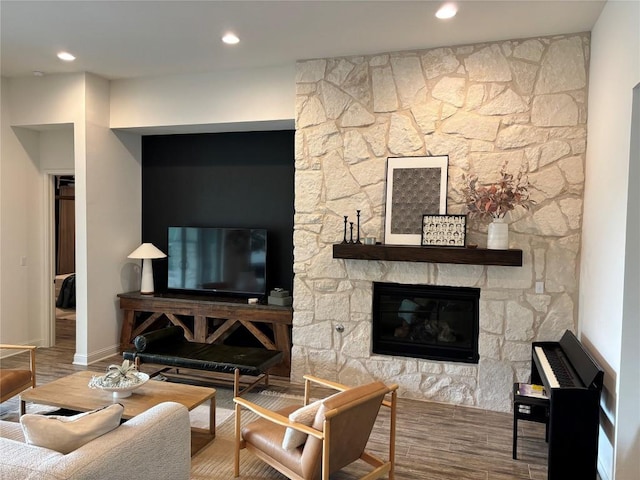 living area featuring baseboards, a fireplace, recessed lighting, and wood finished floors