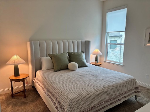 bedroom with baseboards and dark carpet