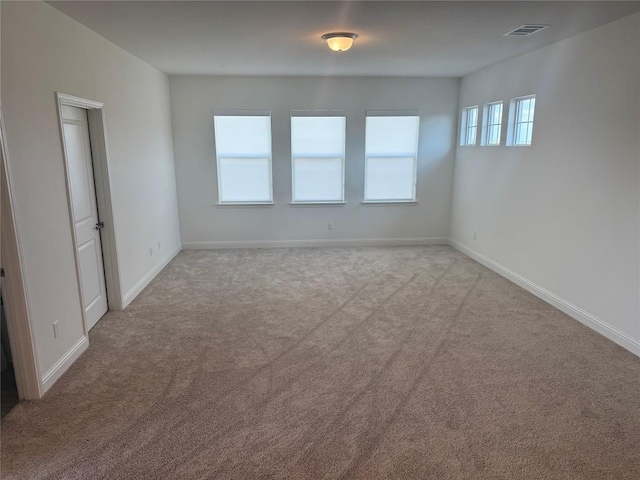 unfurnished room with baseboards, carpet flooring, and visible vents