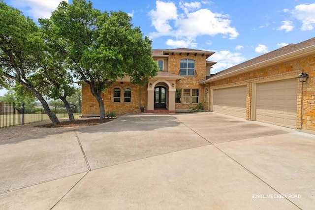 8293 Lime Creek Rd, Leander, TX 78641 - view of front facade featuring driveway, french doors, stone siding, and an attached garage