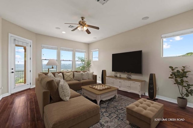 living room featuring baseboards, visible vents, a ceiling fan, and dark wood-type flooring
