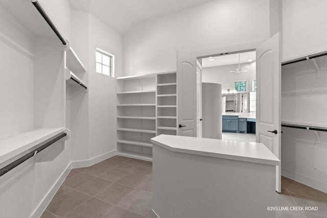 walk in closet with tile patterned flooring and ceiling fan