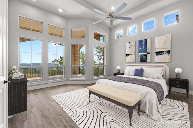bedroom with a high ceiling, a ceiling fan, recessed lighting, and wood finished floors