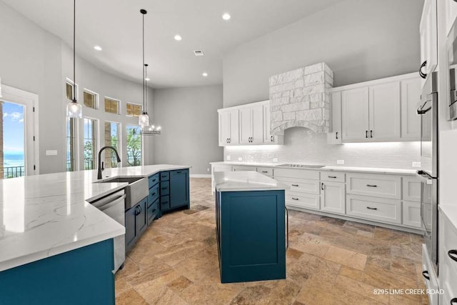 kitchen featuring appliances with stainless steel finishes, blue cabinetry, recessed lighting, decorative backsplash, and a large island with sink